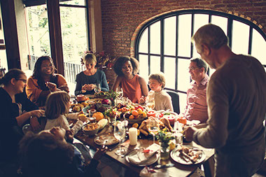 Family and friends sitting around the table having dinner.