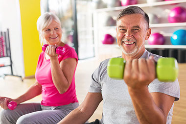 Senior couple exercising in gym.