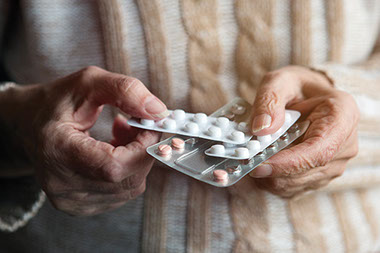 Keeping track of medicines. Close up image of hands holding medications.