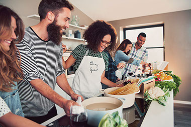 Group of happy friends preparing food.