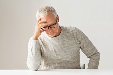 What does PTSD look like? Image of man with hand on forehead.
