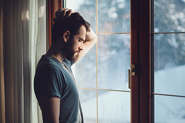Man looking outside a window. Man looking outside a window.