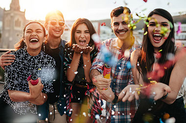 Group of friends popping confetti. Group of friends popping confetti.