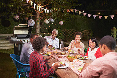 Image of family enjoying dinner together in the backyard.