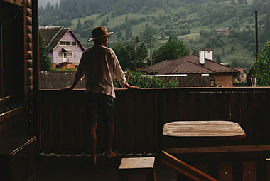 Man standing on porch looking out into the world. Man standing on porch looking out into the world.