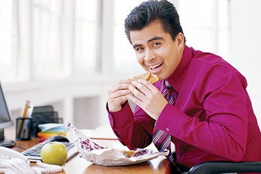 Image of business man eating lunch at his desk.