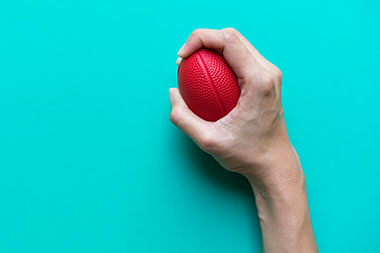 Hand squeezing a stress ball.