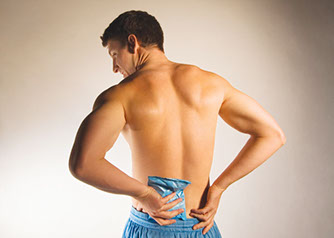 Image of man holding a cold pack on lower back.