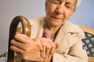 Image of older women holding hand in pain.