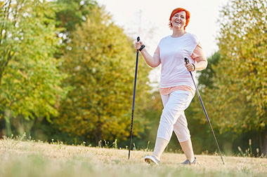 Smiling women walking with walking sticks.
