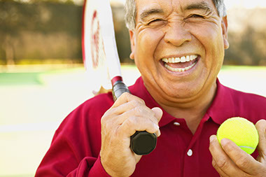 Image of man with racquet and tennis ball.