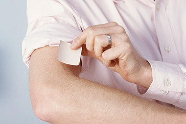 Image of a person placing on a nicotine patch.