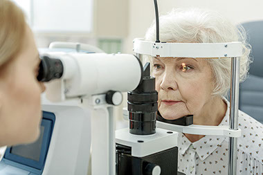 Elderly women getting her eyes checked by a doctor.