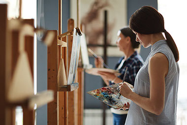 Female painting in an art class.
