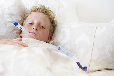 Image of sick boy in bed.