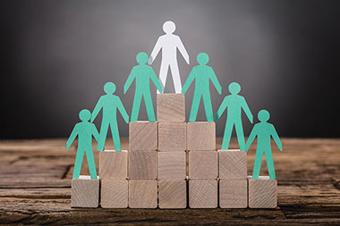 Tier made of blocks with paper cut out of people. Tier made of blocks with paper cut out of people.