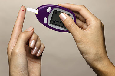 Close up image of female hands taking a sugar glucose reading.