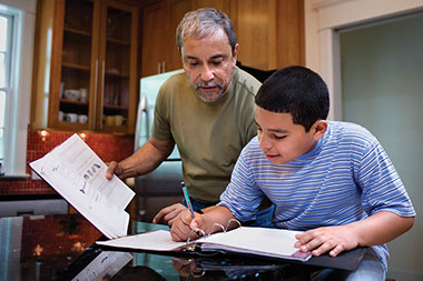 Solve the homework hassle. Image of father helping son with homework.