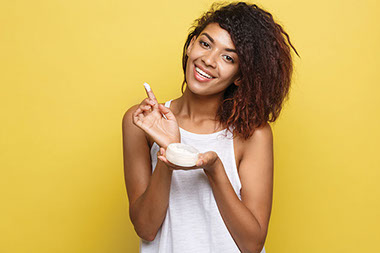 Young female with a jar of lotion.