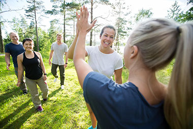 Women giving high-five while walking with friends.