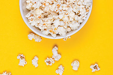 Popcorn in a bowl on a yellow background. Popcorn in a bowl on a yellow background.