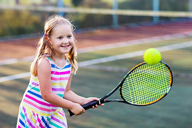 Image of little girl playing tennis.