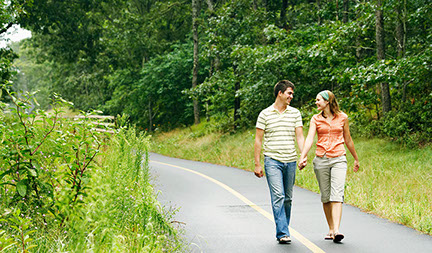 Image of couple walking down a paved trail.