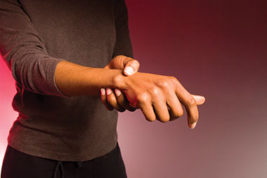 Image of person holding their wrist.