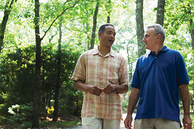 Image of 2 friends walking and talking.