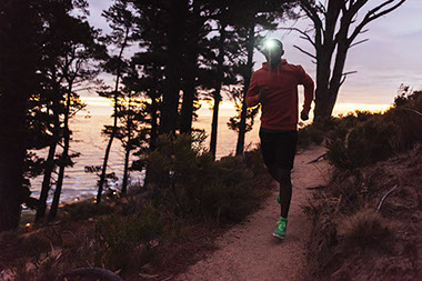Man running at dusk with head light. Man running at dusk with head light.