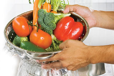 Arm yourself with a vegetable scrubber. Image of vegetables being washed in a scrubber.