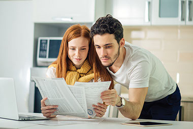 Young couple looking over bills together.