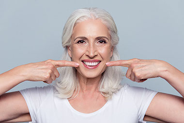 Image of older women smiling and pointing to her mouth. Image of older women smiling and pointing to her mouth.