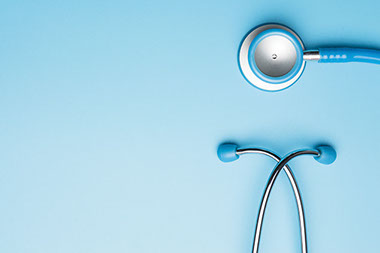 Blue stethoscope on a blue table.