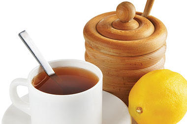 Image of a cup of tea with honey and lemon.