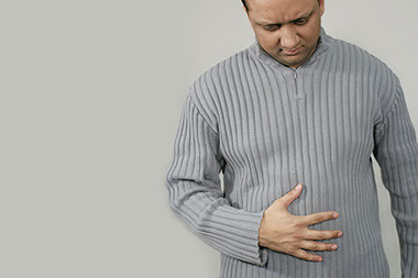 Ulcers not caused by stress. Image of man holding this stomach.