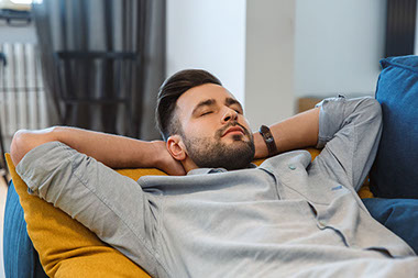 Image of man napping on coach.