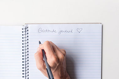 Hand writing in a gratitude journal.
