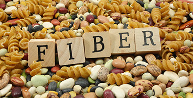 Dietary fiber. A variety of fiber enriched food with the word fiber spelled out with blocks.