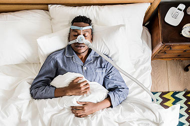 Man wearing a CPAP machine while sleeping.