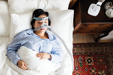 Women sleeping while wearing a CPAP machine.