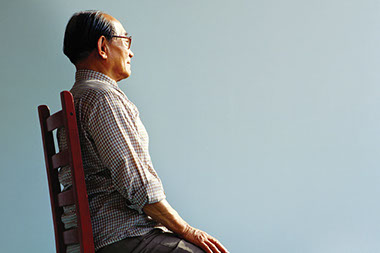 Image of older man sitting on chair.