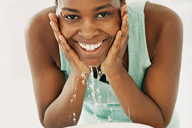 Image of young women washing her face.