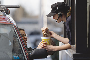 Image of women picking up food from a drive-thru.