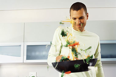 Image of a man pan stirring vegetables. Image of a man pan stirring vegetables.